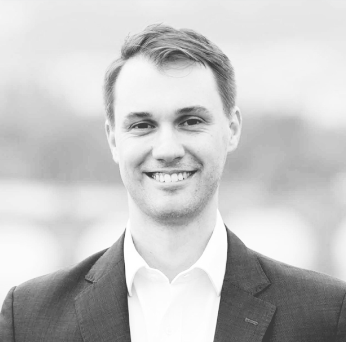 Portrait of a woman with brown hair on a flat gray background.